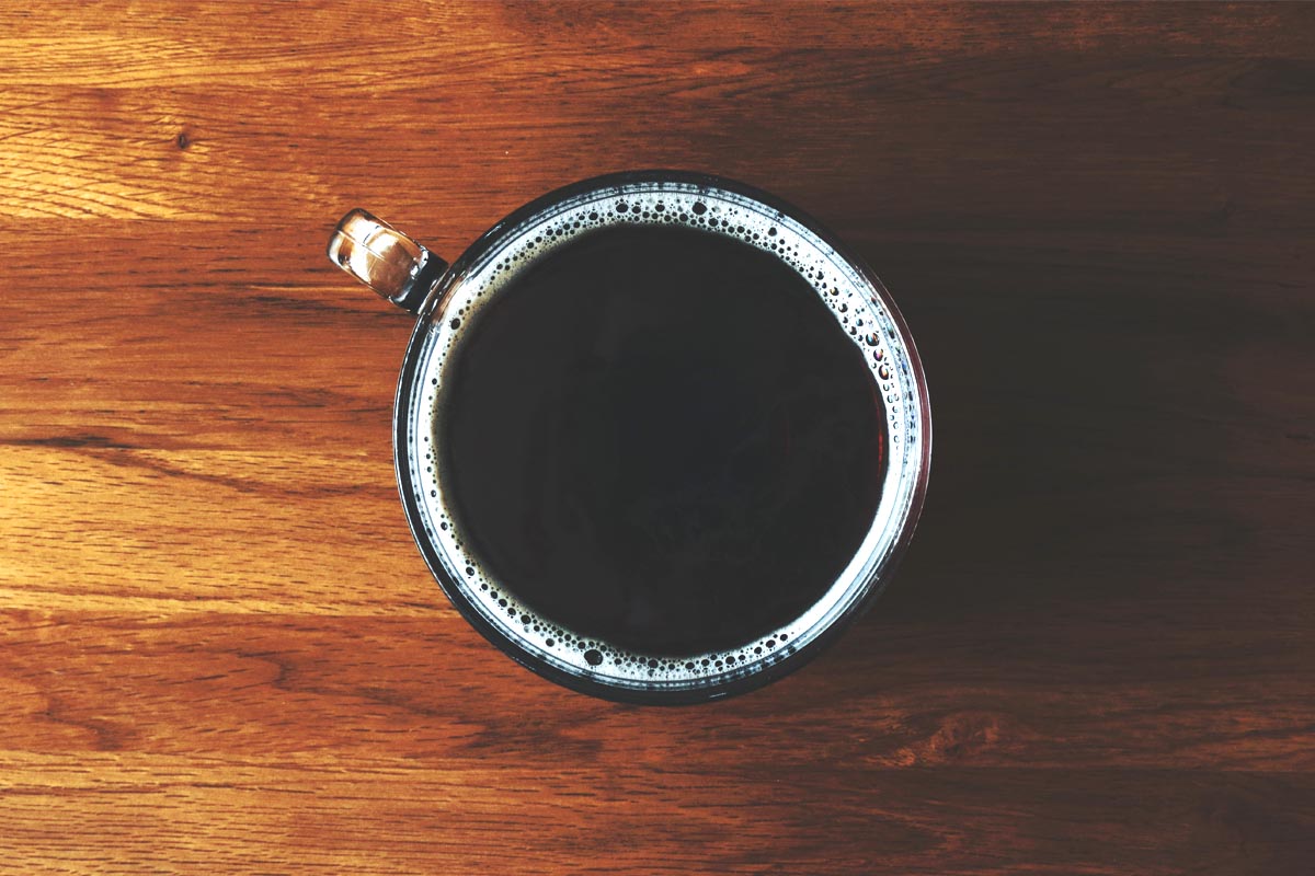 Closeup of a coffee cup filled with black coffee